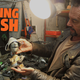 A photo of British artist Joe Rush in his workshop, he is holding parts of an old drill.